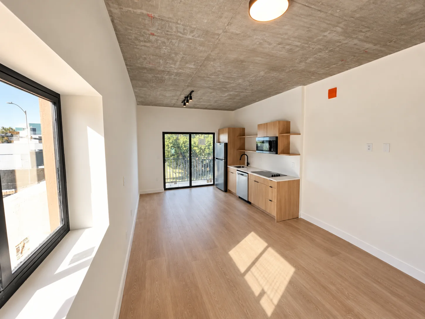 The Cafecito Studio as delivered: empty, with concrete ceiling, wood-look floors and kitchen