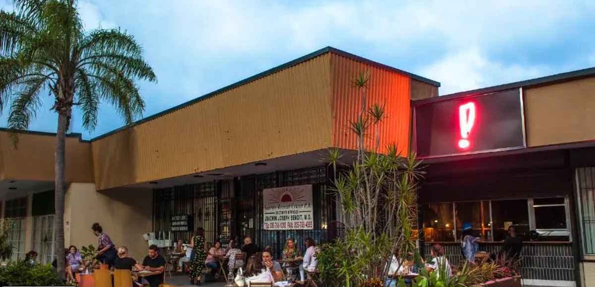 Boia De's strip-mall storefront on NE 2nd Avenue, with a red neon exclamation point and diners at sidewalk tables